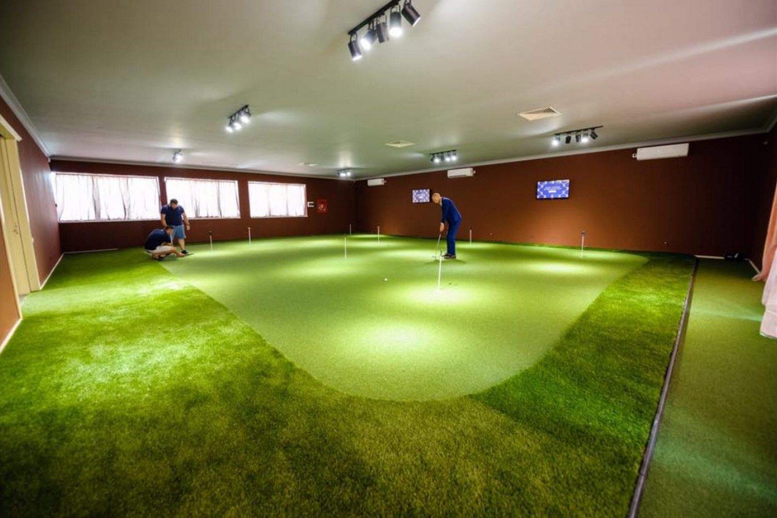 Indoor putting green with contoured fringe and multiple holes