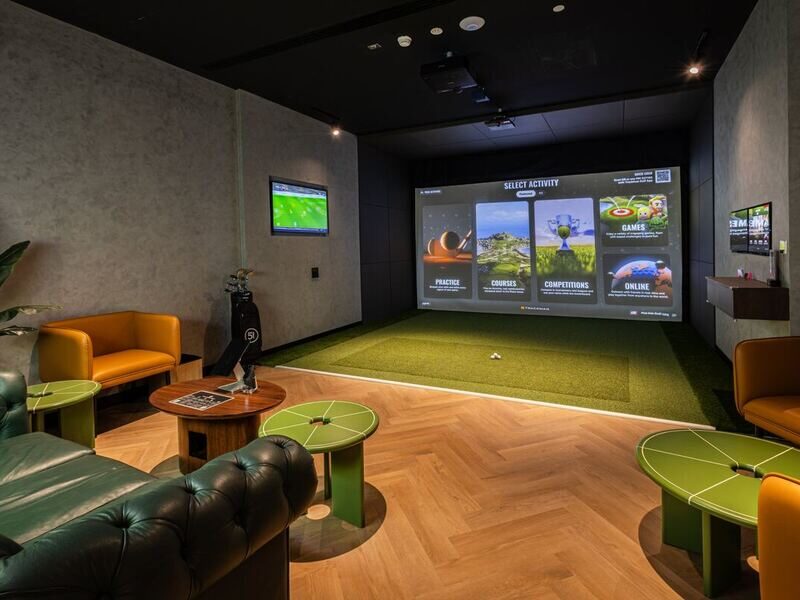 Simulator suite with lounge seating at Five Iron Golf Business Bay, Dubai